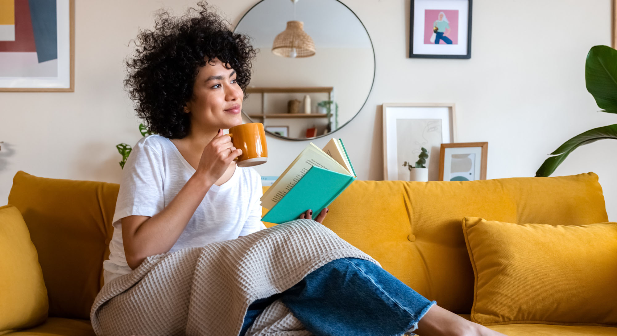 Woman reading and drinking coffee at home.
